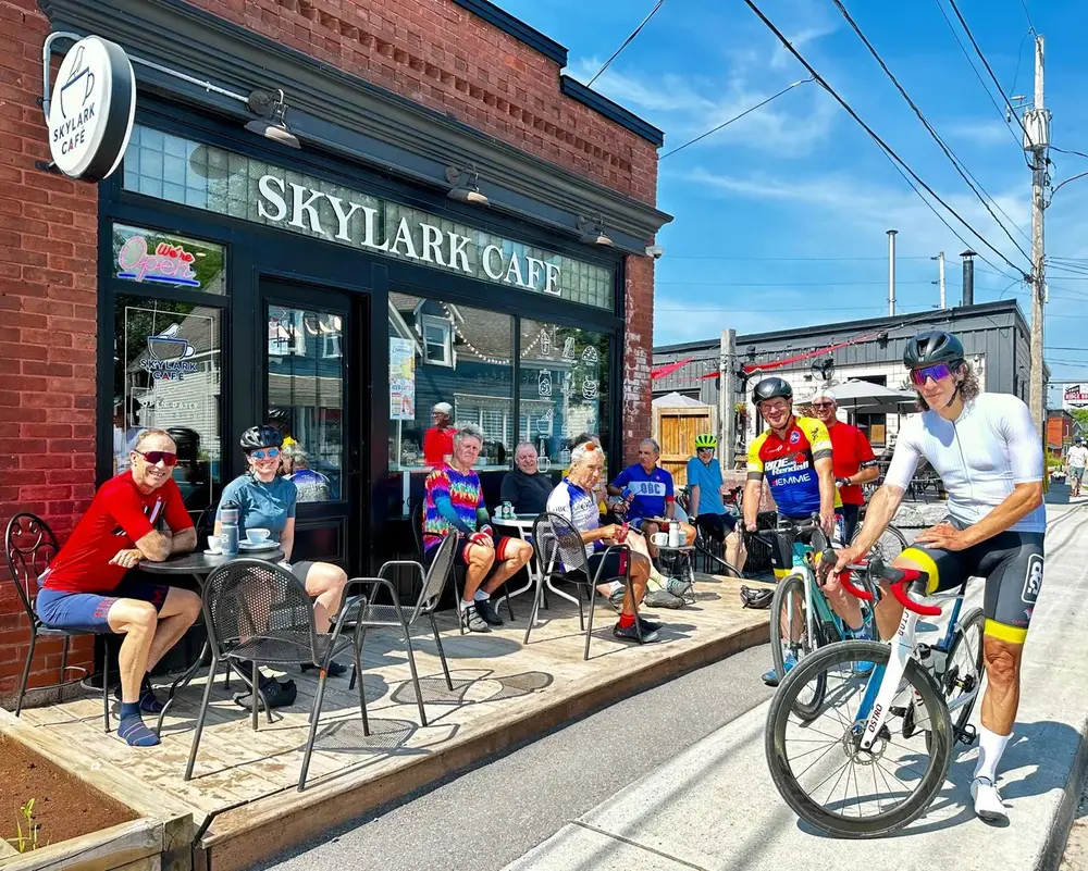 Cyclists enjoying coffee together outside Skylark Café in Carp