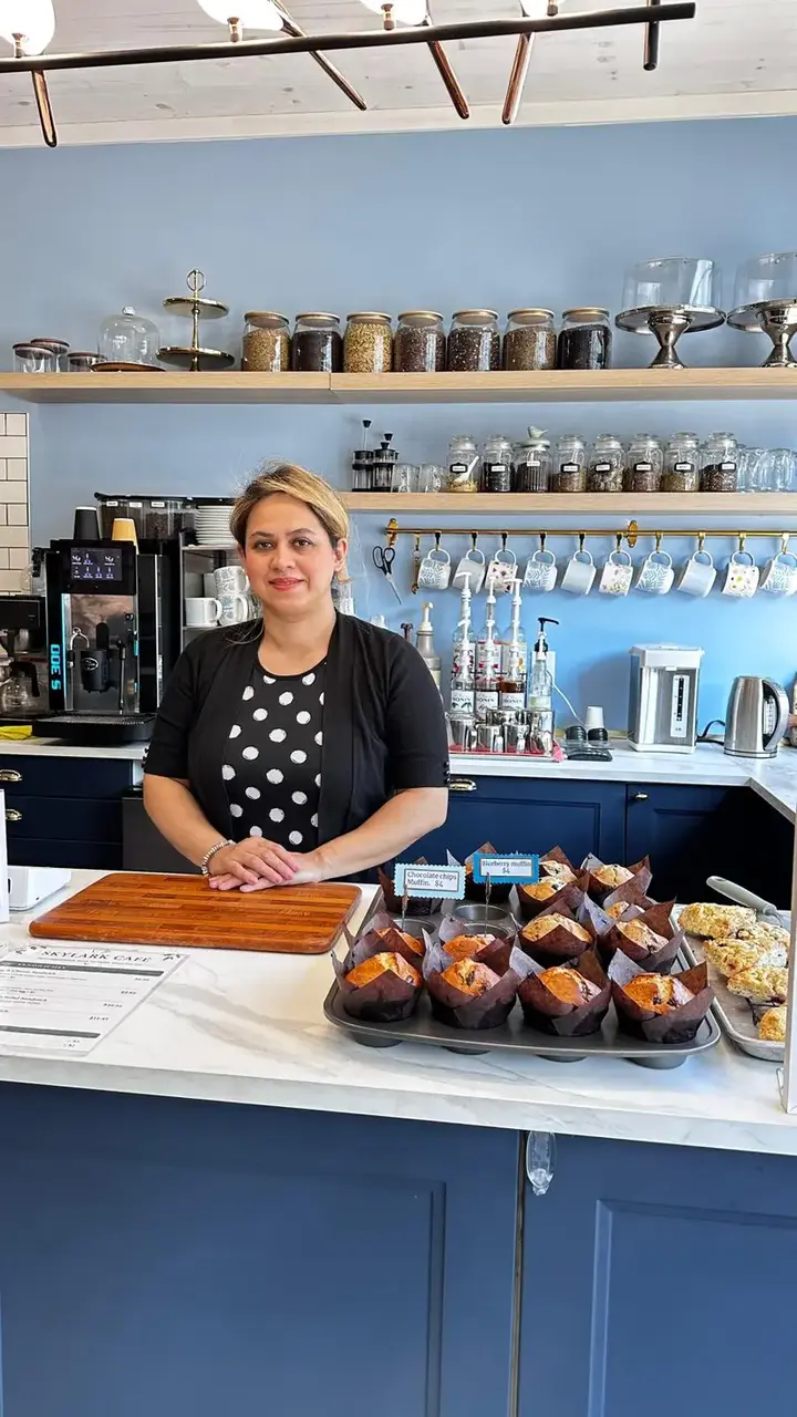 Sara behind the Skylark Café counter with freshly baked muffins and scones